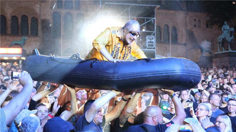 Das Foto zteigt einen Musiker der Band Völkerball, der sich in einem Schlauchboot auf den Händen der Fans tragen lässt.