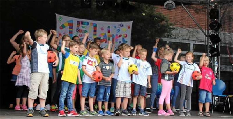 Mit dem WM-Song „54, 74, 90, 2006“ von den Sportfreunden Stiller stimmen die Kinder der Clemens-Schule auf das bevorstehende Fußball-Großereignis ein. Dabei haben einige sogar die Trikots ihrer Lieblingsmannschaften an.  Foto: Hohaus
