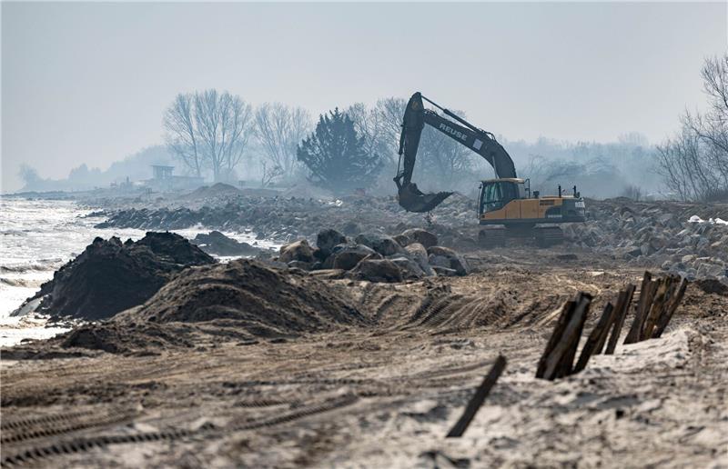 Niedersachsen sagt Inseln Hilfe bei Stränden zu Mit einem Bagger werden große Steine am Strand am Hafen von Damp verladen.