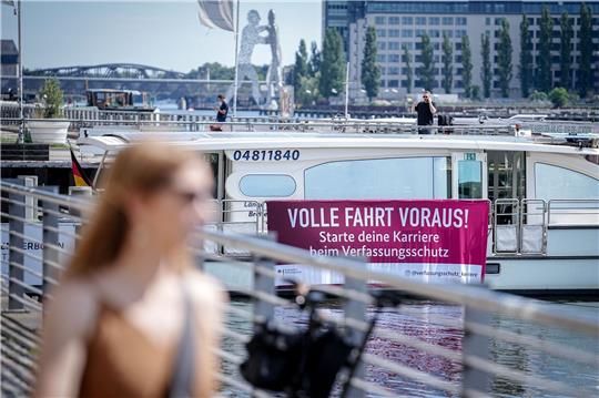 Mit einem Plakat an einem Solarschiff wirbt der nationale Nachrichtendienst für Nachwuchs.