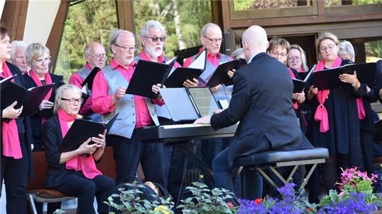 Mit einem kurzweiligen Programm erfreut der Solinger Chor Aufderhöhe unter Leitung von Thorsten Schäffer die 60 Zuhörerinnen und Zuhörer auf der Außenbühne des Kurgastzentrums zum Kurpark.