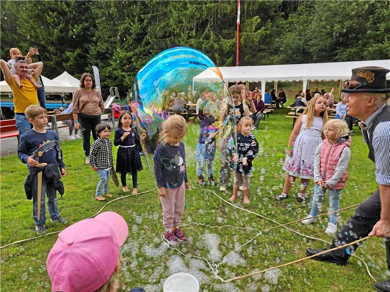 Altenau: Schwimmbad Okerteich wird zum bunten Lichtermeer Mit einer Riesenluftblase hüllt Jo von Usslar beim Lichterfest in Altenau die Kinder ein, die nacheinander selbst einmal darunter stehen möchten. Foto: Weiss