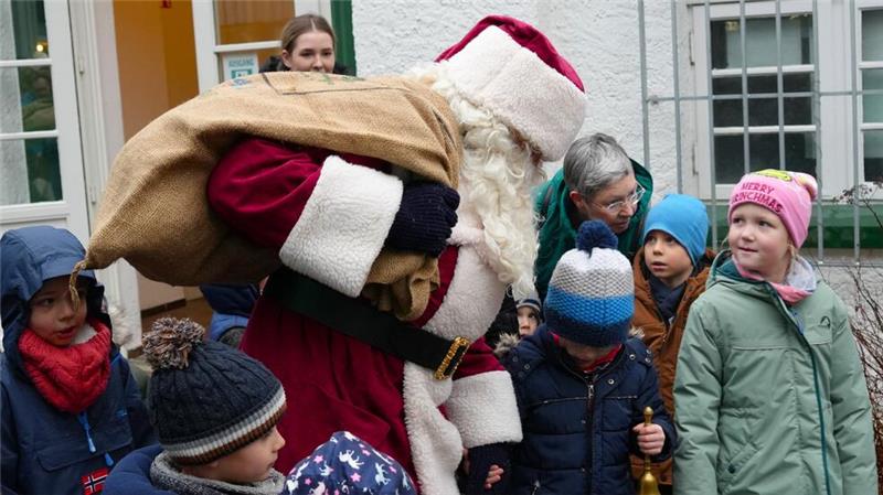 Mit einer Schar Kinder um sich herum begibt sich der Nikolaus von der Talstation zur Eisbahn.