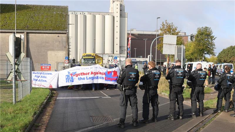 Protestierende blockieren Zufahrten von Hafendienstleister Mit einer Sitzblockade protestieren Aktivisten vor der Zufahrt eines Hafendienstleisters in Bremen-Walle.