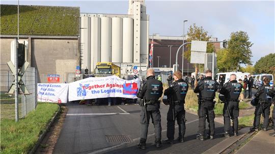 Mit einer Sitzblockade protestieren Aktivisten vor der Zufahrt eines Hafendienstleisters in Bremen-Walle. 