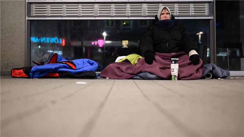 Mit mehreren Jacken, Decken und Schlafsäcken hält sich der Obdachlose Kevin bei der Eiseskälte warm.