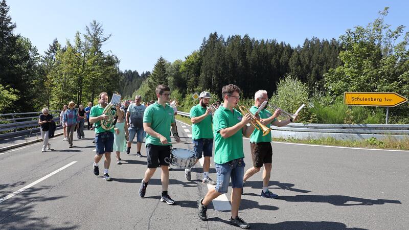 Mit musikalischer Begleitung der Blechkapelle Harzaranka marschiert der Tross vom Bootsanleger zurück nach Schulenberg.