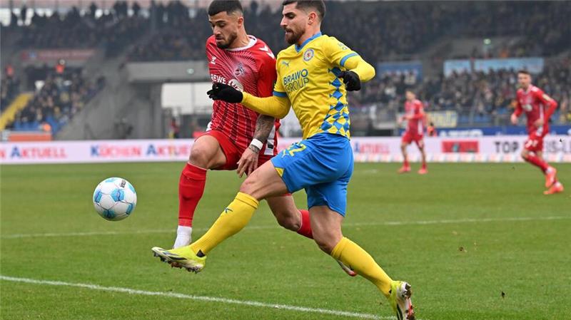 Mit vollem Einsatz: Braunschweigs Fabio Di Michele Sanchez (r) und Kölns Jusuf Gazibegović im Zweikampf um den Ball.