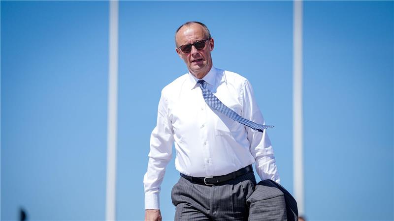 Mit wehendem Schlips und Sonnenbrille: Bundeskanzler Merz geht auf dem militärischen Teil des Flughafens BER zum Airbus A321 der Luftwaffe, um nach Zypern zu fliegen. 