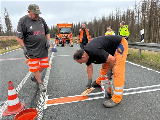 Mitarbeiter der Firma „Meyer Verkehrstechnik“ aus Hasselfelde bringen am 10. Juli vergangenen Jahres die Rüttelstreifen auf der B 4 zwischen Braunlage und Hohegeiß an. Seit dem gab es nur noch einen Motorradunfall am Kesselberg. Archivfoto: Eggers