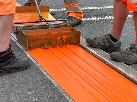 Mitarbeiter der Firma Meyer installieren die Rüttelstreifen auf der B 4. Foto: Eggers