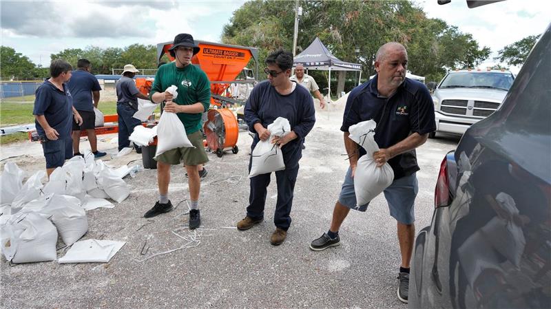 Florida bereitet sich auf Hurrikan „Idalia” vor Mitarbeiter der Park- und Freizeitbehörde von Tampa in Florida helfen Anwohnern beim Verladen von Sandsäcken.