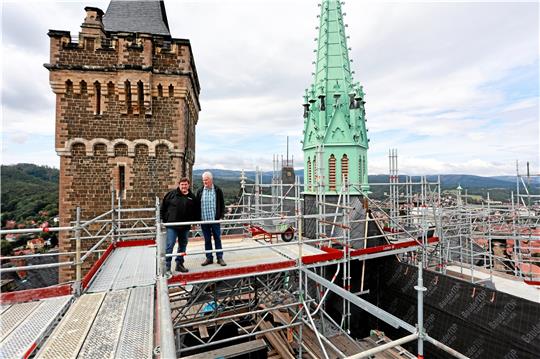 Mitarbeiter der beteiligten Baufirmen stehen auf einem Baugerüst über dem Schloss Wernigerode. Das Gerüst wurde für die Sanierung der Dächer an Kirchenschiff und Glockenturm benötigt. Es wird nun ab- und an anderer Stelle auf dem Grundstück wieder aufgebaut, die Sanierung läuft weiter.  Foto: Bein
