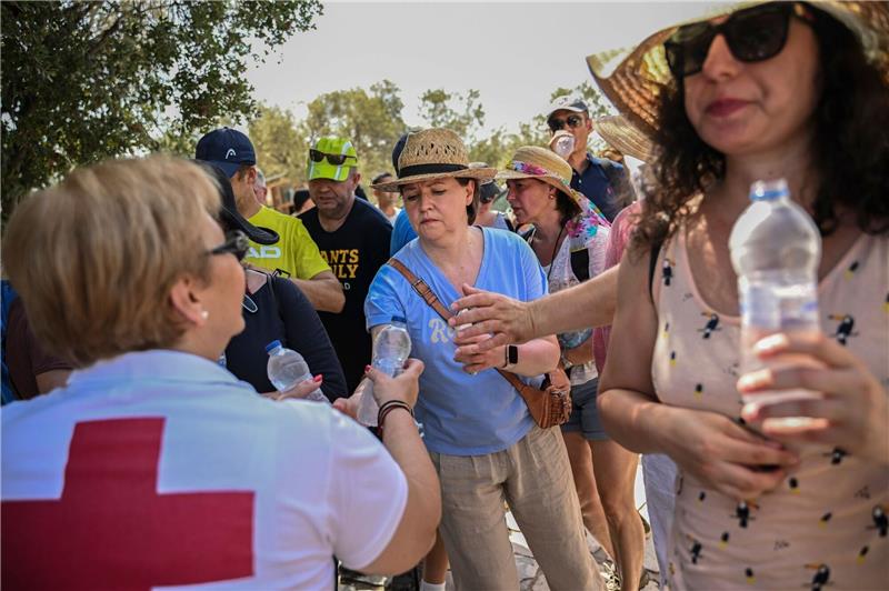 Keine Entwarnung für Hitze in Südeuropa Mitarbeiter des Griechischen Roten Kreuzes verteilen vor der Akropolis Wasserflaschen an Besucher.