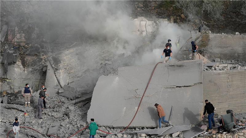 Mitarbeiter des Zivilschutzes und Zivilisten überprüfen ein zerstörtes Gebäude, das von einem israelischen Luftangriff in dem Ort im Südlibanon getroffen wurde.