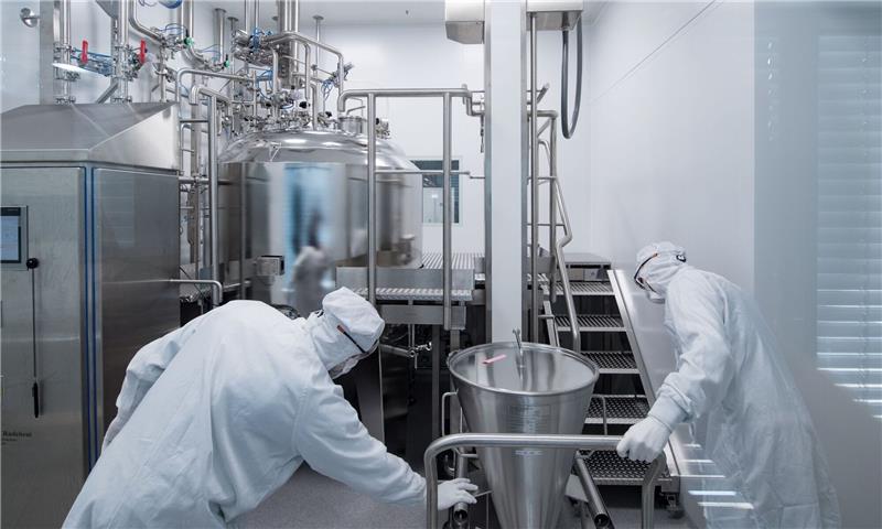 Pharmabranche erwartet nach Impfstoffboom Umsatzminus Mitarbeiter eines Pharmaunternehmens arbeiten in einem Reinraum an einer Gelmischanlage.