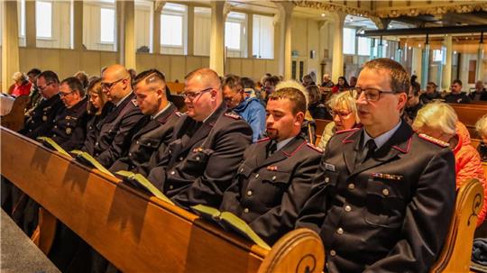 Mitglieder der Feuerwehr rund um Stadtbrandmeister Markus Finck (r.) sind beim ersten Gottesdienst nach dem Brand dabei.