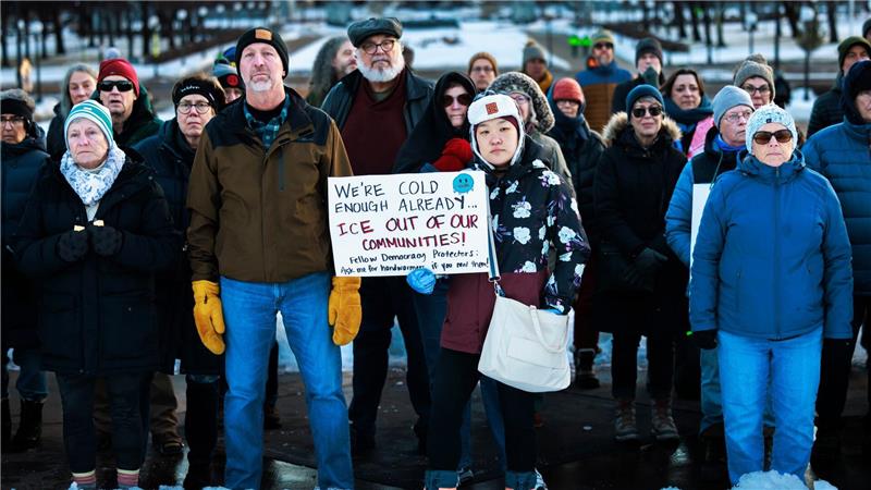 Mitglieder der Gemeinde stehen während einer Mahnwache zu Ehren einer Frau, die von einem ICE-Beamten in Minneapolis erschossen wurde, vor dem Minnesota State Capitol zusammen.