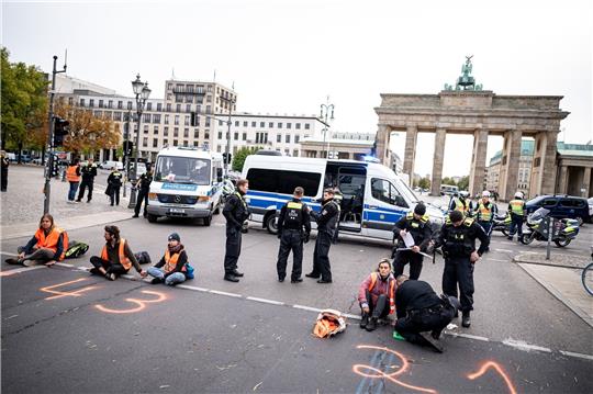 Mitglieder der letzten Generation haben sich auf die Straße des 17. Juni vor dem Brandenburger Tor geklebt.