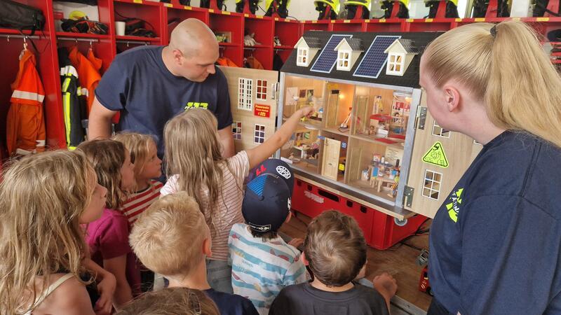 Mithilfe eines Rauchdemohauses lernen Kinder, wie sich Qualm durch offene Türen ausbreitet.