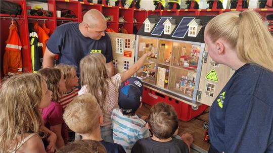 Mithilfe eines Rauchdemohauses lernen Kinder, wie sich Qualm durch offene Türen ausbreitet.