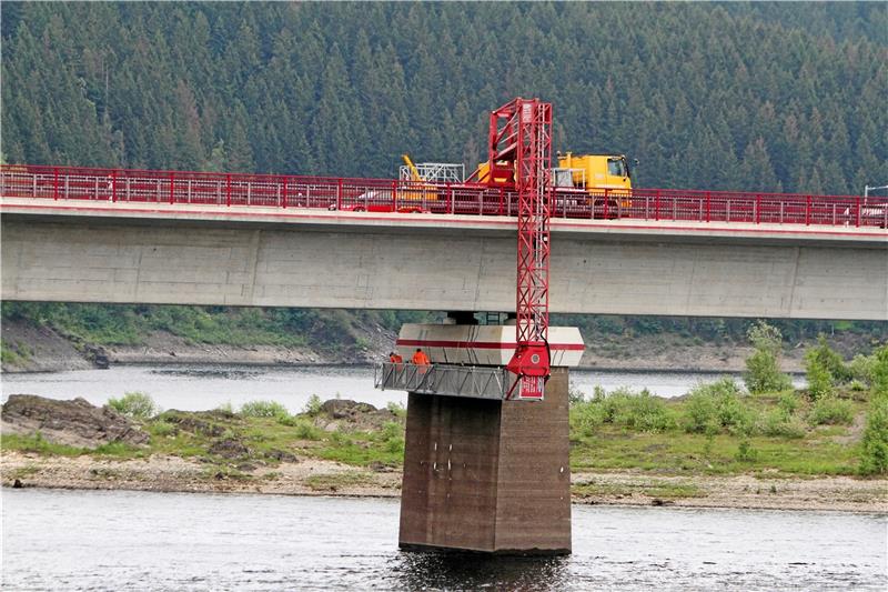 Mithilfe eines so genannten Brückenuntersichtsgerätes – eine Art mobile Arbeitsbühne – bearbeiten Fachleute Risse im Beton der Weißwasserbrücke. Foto: Bruns