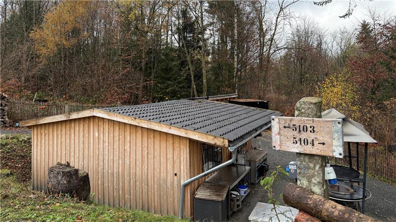 Mitten im Wald steht ein kleines Gebäude aus Holz, dort soll das Feriendorf entstehen.