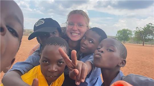 Amalia Saupe zeigt bei einem Selfie mit Kindern aus Mukuni das Victory-Zeichen.