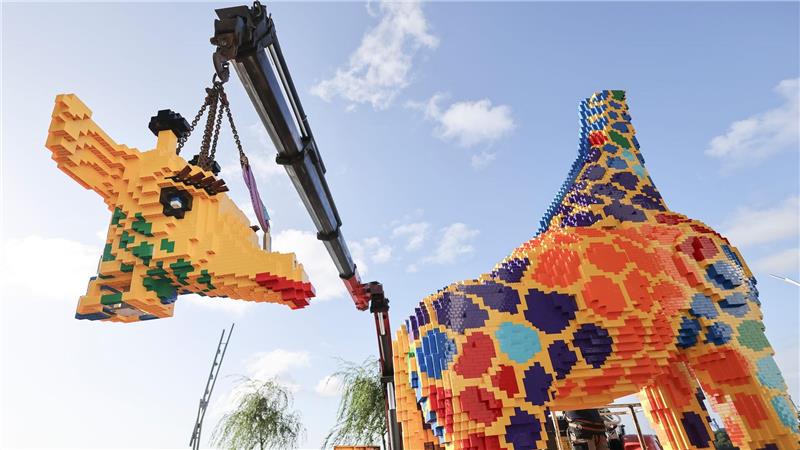 Modellbauer arbeiten an der finalen Arbeiten an einer lebensgroßen Lego-Giraffe auf dem Chicagokai vor dem Westfield Hamburg-Überseequartier in der Hafencity.