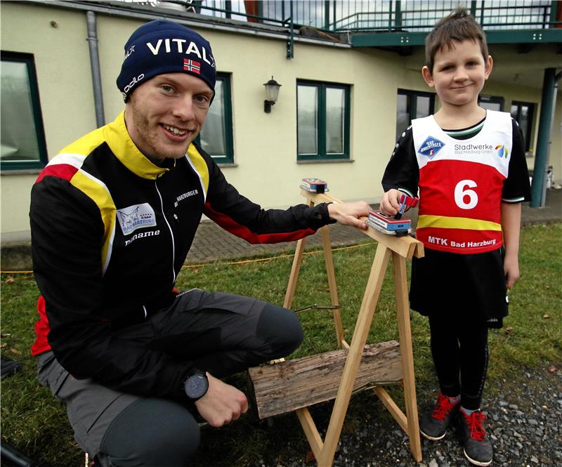 Auf der Strecke mit Captain America Moderator Matti Bruns und der sechsjährige Juri Kampe demonstrieren die Zeitmessung, die bei den Bambini allerdings nicht zum Einsatz kommen muss.