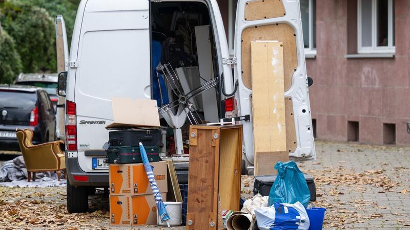 Möbel und Umzugskartons stehen vor einem Transporter an einem Wohnhaus in Leipzig. (Symbolbild)