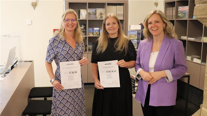Morea Deden, Marketing-Leiterin der Stiftung Welterbe im Harz, Lea Dirks, wissenschaftliche Mitarbeiterin der Welterbe-Stiftung und Judith von Hof, Leiterin der Tourist-Info (von re.) mit den Zertifikaten. Hier sorgt ein zusätzlicher Counter in der idealen Höhe für Rollis (links im Bild) für inklusiven Gäste-Service. Foto: Kaspert