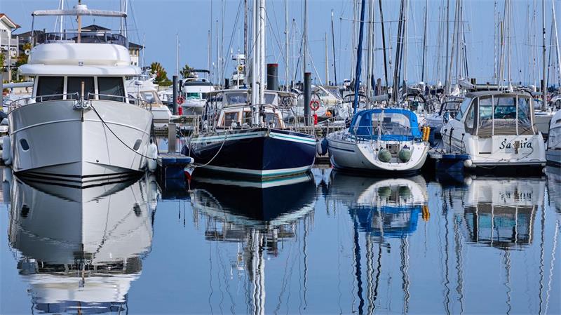 Motor- und Segelboote spiegeln sich in der Marina im Wasser. Teilweise sonnig und mit milden Temperaturen zeigt sich das Herbstwetter in Norddeutschland von seiner freundlichen Seite.