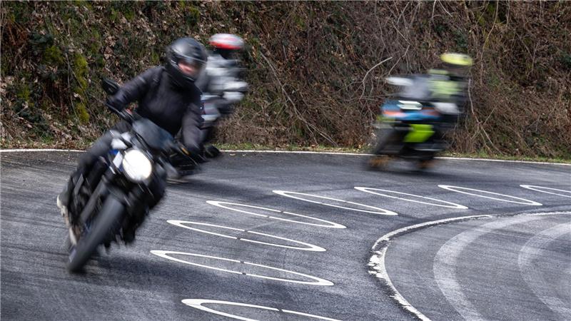 Motorradfahrer durchfahren die mit Ellipsen markierte Kurve des Verkehrsversuches bei der Eröffnung der Motorradsaison.