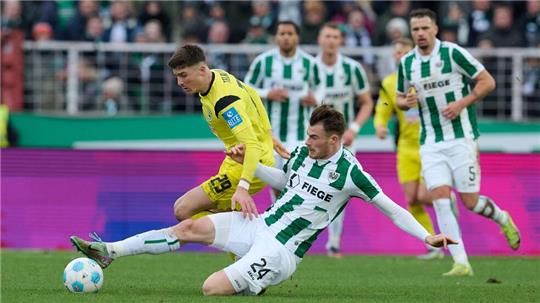 Münsters Niko Koulis verhindert eine Chance des Ulmers Semir Telalovic (l).