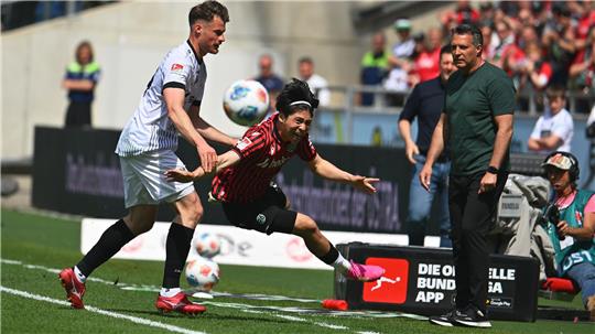 Münsters Verteidiger Niko Koulis (l) foult Hannovers Daisuke Yokota.