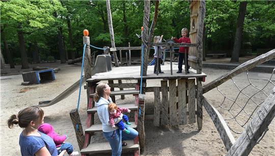 Blick auf einen Kinderspielplatz, auf denen sich Mütter mit Kindern aufhalten.