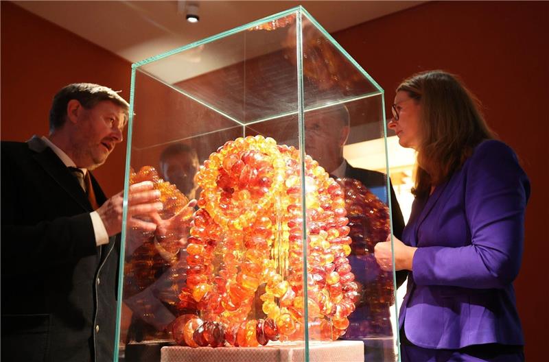 Ribnitz-Damgarten erwirbt Bernstein-Kunstsammlung Museumsleiter Axel Attula (l-r) und Kulturministerin Bettina Martin betrachten das Exponat «Wasserfall» oder «Goldener Kettenberg».