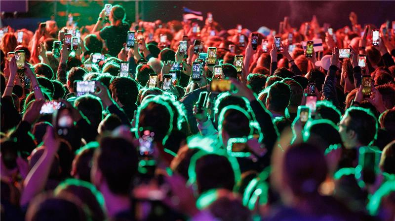 Musikfans feiern im Eurovision Village in Wien vor dem Historischen Rathaus bei einem Konzert. 