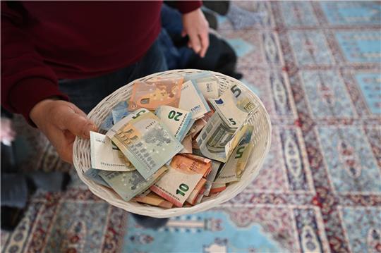 Muslimische Gläubige spenden Geld in der DITIB Moschee in Stuttgart-Feuerbach beim Freitagsgebet für die Opfer der Erdbebenkatastrophe in der Türkei und Syrien. Foto: picture alliance/dpa | Bernd Weißbrod