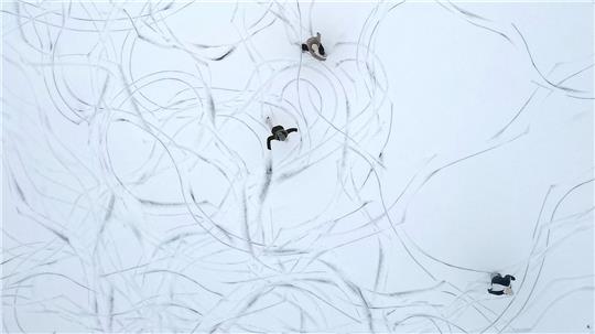 Muster im Schnee: Eine Luftaufnahme zeigt Schlittschuhläufer auf einem zugefrorenen See in Österreich.