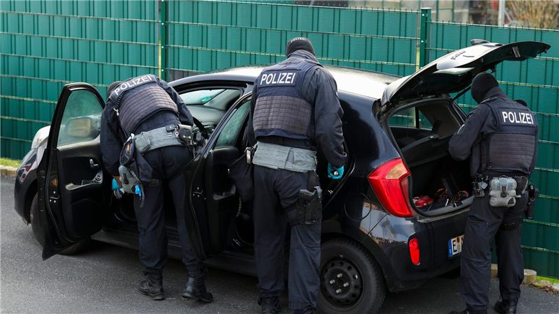 Nach Sonderzug-Gewalt: Polizeibeamte durchsuchen mehrere Pkw vor einem Wohnhaus.