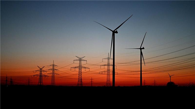 Nach Sonnenuntergang stehen Windräder auf einem Feld bei Pulheim.