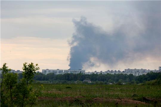 Nach dem Beschuss durch russische Truppen steigt eine Rauchsäule hinter Wohnhäusern in Charkiw auf.