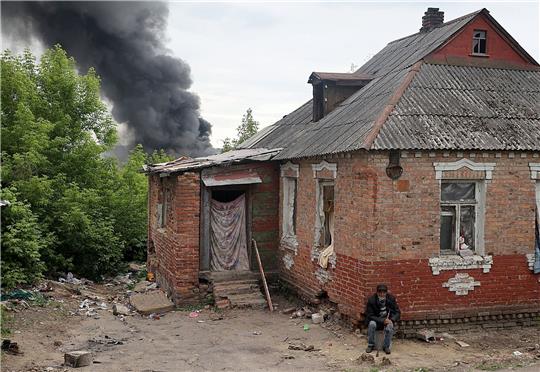 Nach dem Beschuss durch russische Truppen steigt hinter einem Haus in Charkiw eine Rauchsäule auf.