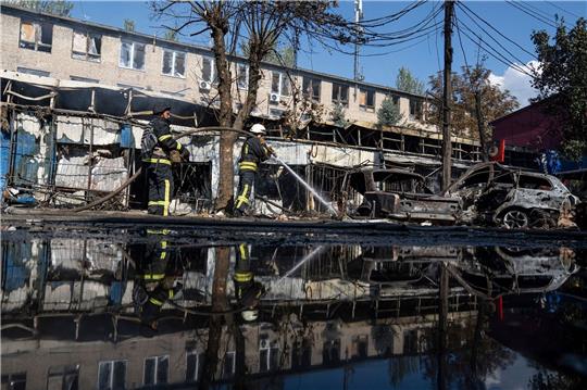 Nach dem Beschuss eines Marktplatzes in der ostukrainischen Stadt Kostjantyniwka löschen Rettungskräfte ein Feuer.