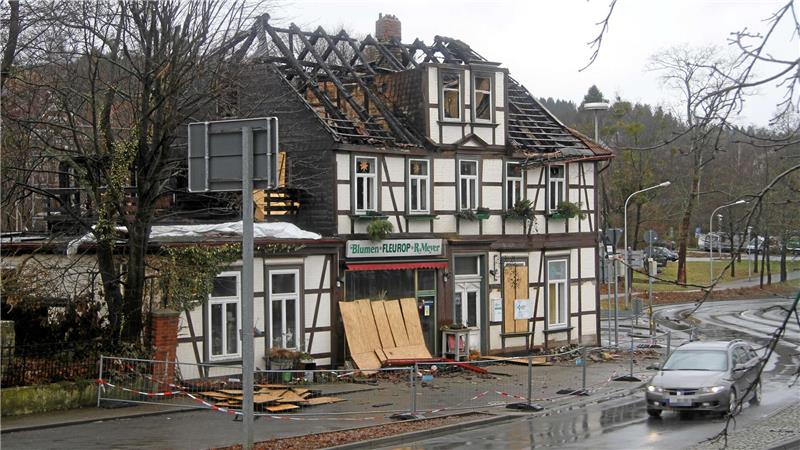 Fachwerkhaus mit teilweise zerstörtem Dach, abgesperrtem Bereich und einem parkenden Auto davor.