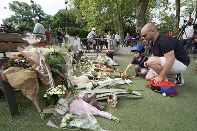 Frankreich sucht nach Messerattacke Antworten Nach dem Messerangriff in Annecy haben Menschen in der Nähe des Tatorts Blumen und Kuscheltiere abgelegt und gedenken der Opfer.