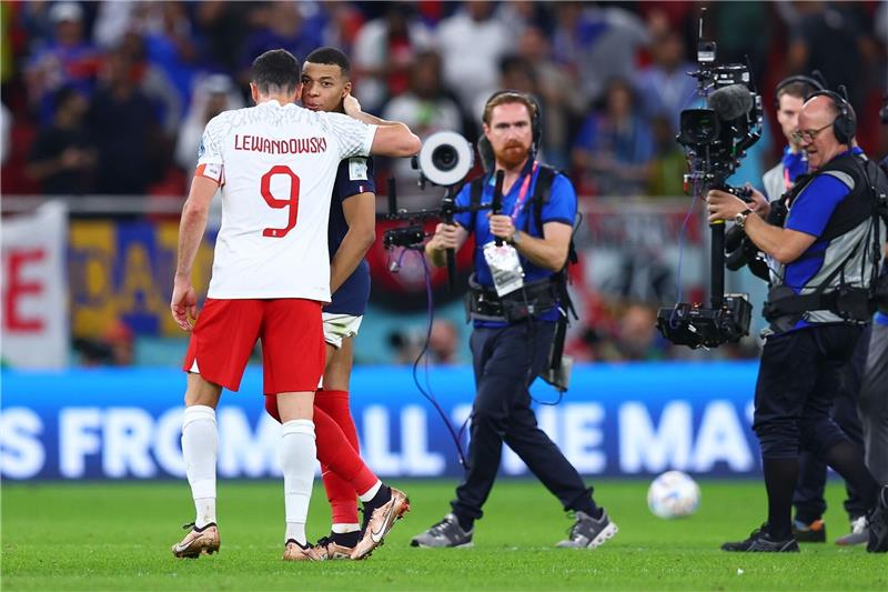 Nach dem Spiel umarmt Robert Lewandowski (l) Frankreichs Doppeltorschützen Kylian Mbappé.