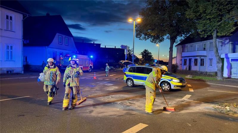 Nach dem Zusammenstoß der beiden Autos nehmen die Einsatzkräfte der Feuerwehr die ausgelaufenen Betriebsstoffe auf.